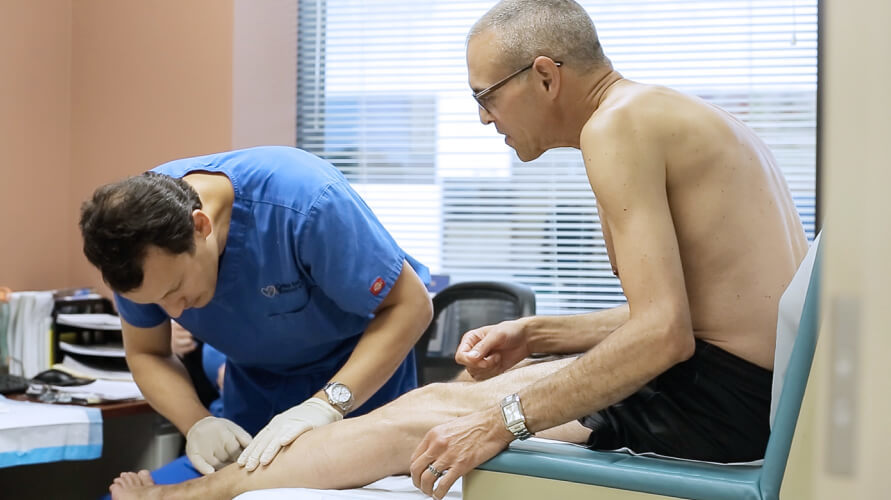 El Doctor Eddie Fernandez realiza un examen físico indoloro mientras el paciente está sentado