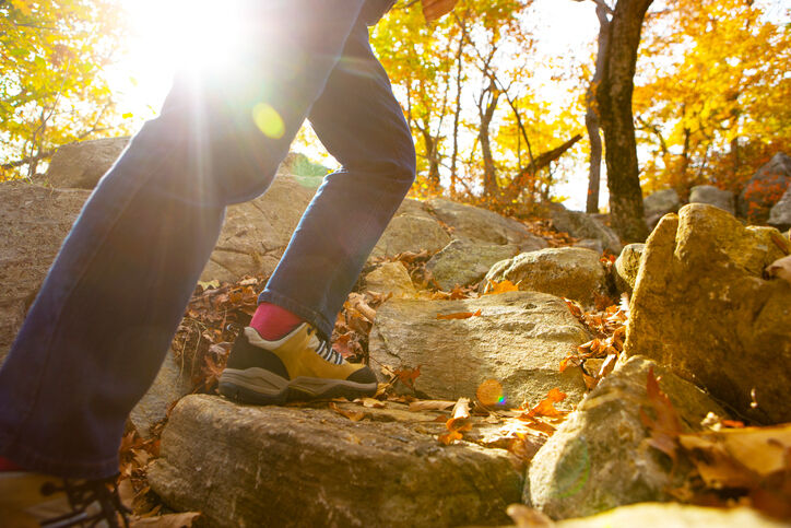 Womans legs walking up rocks in fall